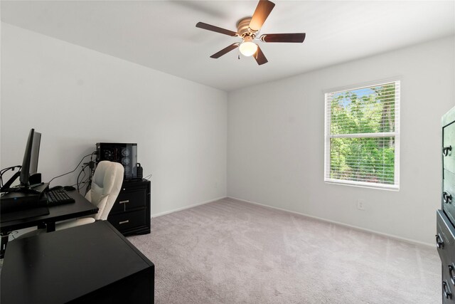 office featuring light colored carpet, a ceiling fan, and baseboards