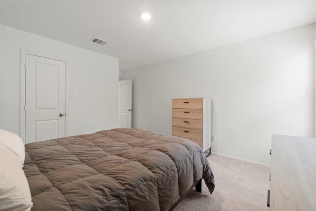 bedroom with visible vents, baseboards, and light carpet