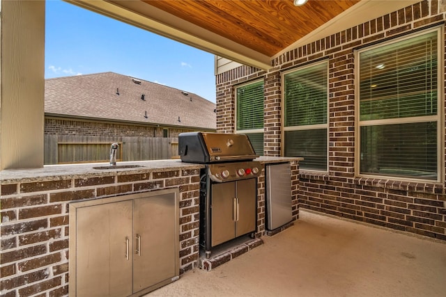 view of patio / terrace featuring grilling area, fence, a sink, and area for grilling