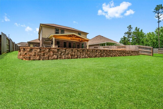rear view of property with a yard and a fenced backyard