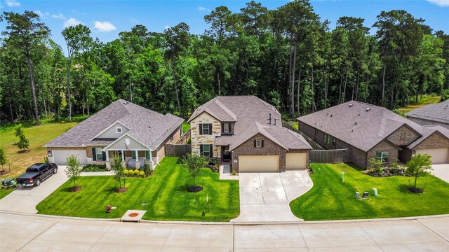 view of front of house with a front lawn, fence, driveway, and stone siding
