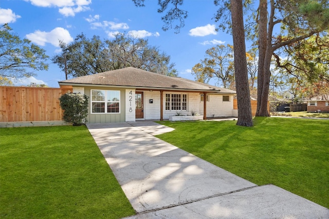 view of front of property with fence, a shingled roof, a front lawn, board and batten siding, and concrete driveway