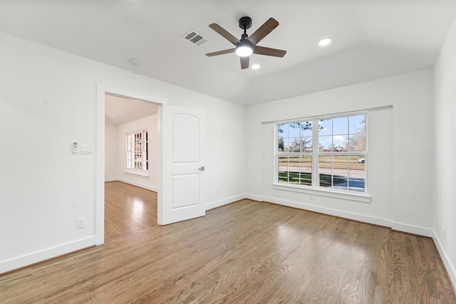 empty room featuring ceiling fan, visible vents, a wealth of natural light, and wood finished floors
