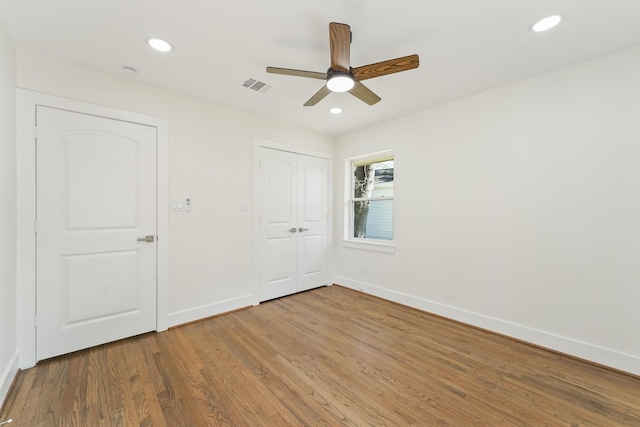 unfurnished bedroom featuring recessed lighting, baseboards, visible vents, and wood finished floors