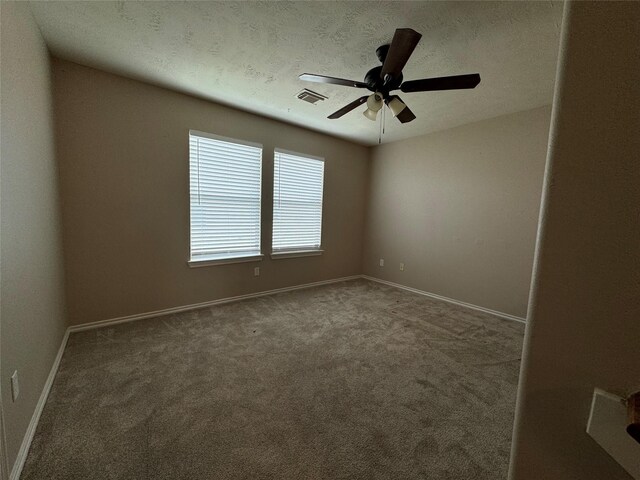 unfurnished room with baseboards, ceiling fan, carpet flooring, and visible vents