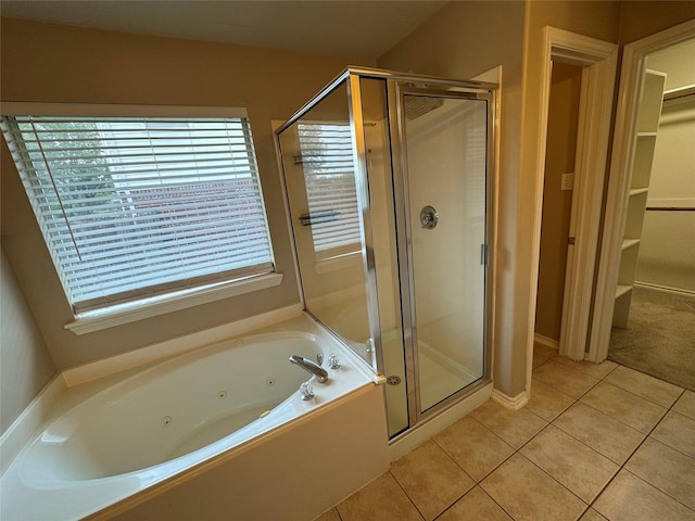 bathroom featuring a spacious closet, a tub with jets, tile patterned flooring, and a stall shower