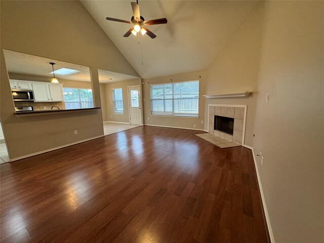 16407 Thyme Green Ln, Cypress, TX 77433 - unfurnished living room with dark wood-type flooring, high vaulted ceiling, a ceiling fan, healthy amount of natural light, and baseboards