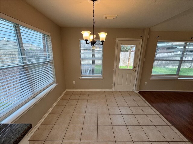 16407 Thyme Green Ln, Cypress, TX 77433 - unfurnished dining area featuring light tile patterned flooring, a chandelier, and baseboards