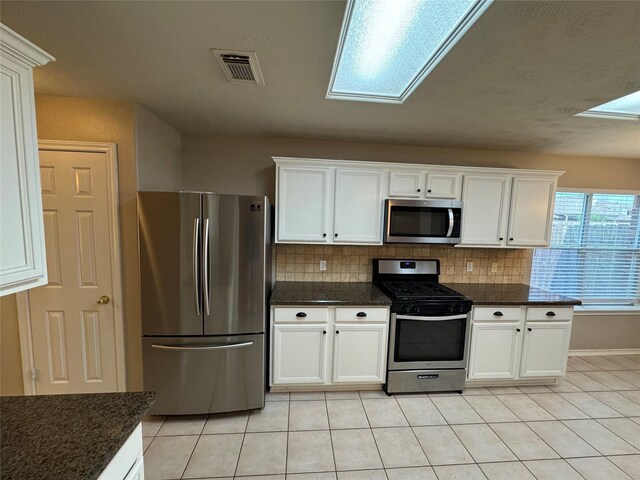 16407 Thyme Green Ln, Cypress, TX 77433 - kitchen with stainless steel appliances, light tile patterned floors, and white cabinets