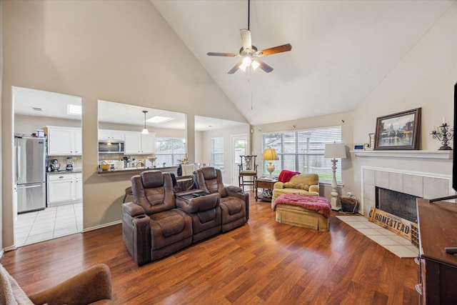 16407 Thyme Green Ln, Cypress, TX 77433 - living area with high vaulted ceiling, light wood finished floors, ceiling fan, a fireplace, and plenty of natural light