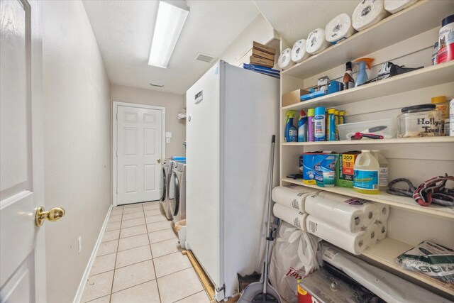 16407 Thyme Green Ln, Cypress, TX 77433 - laundry area with light tile patterned floors, washing machine and clothes dryer, and baseboards