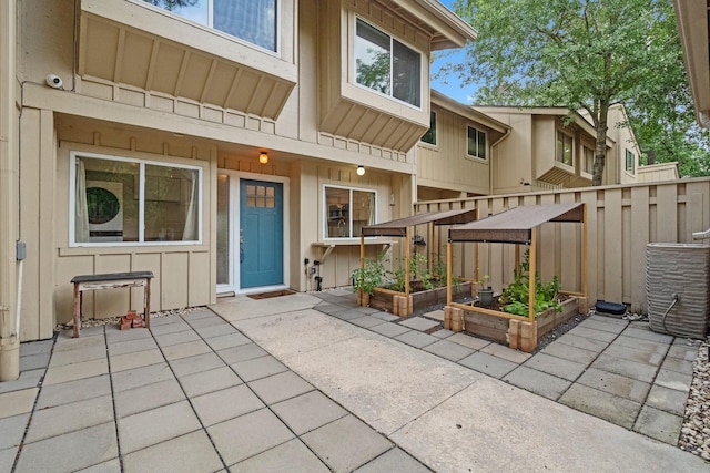 exterior space with central air condition unit, fence, and a garden