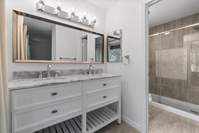 full bath with a sink, a stall shower, toilet, and double vanity