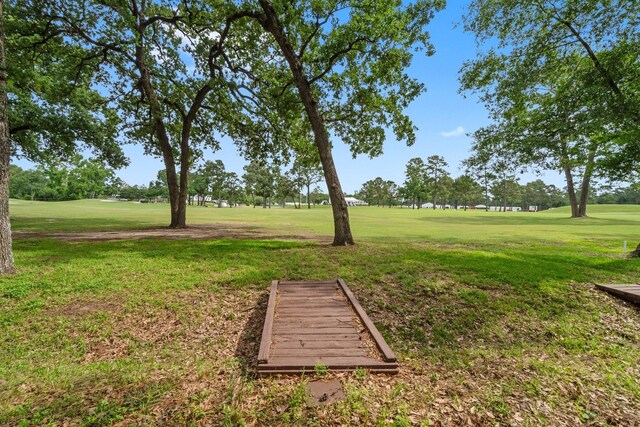 view of home's community featuring view of golf course and a yard