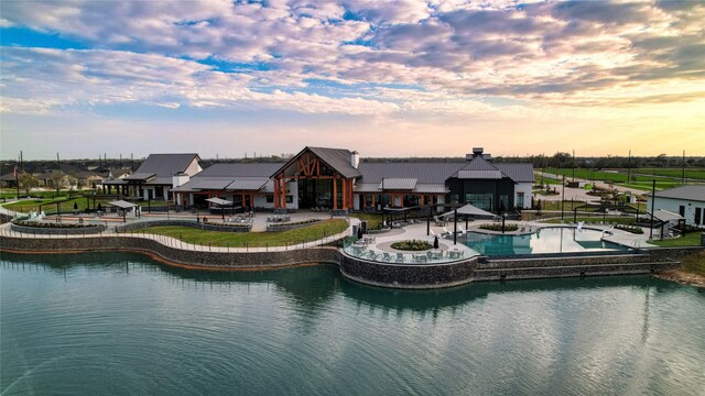 exterior space with a community pool, a patio, and a water view