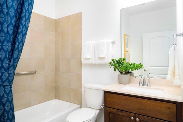 bathroom with toilet, shower / bath combination with curtain, and vanity