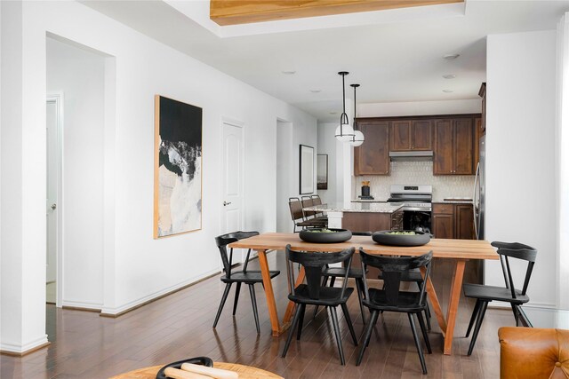 kitchen with electric range, dark brown cabinetry, a center island, backsplash, and under cabinet range hood