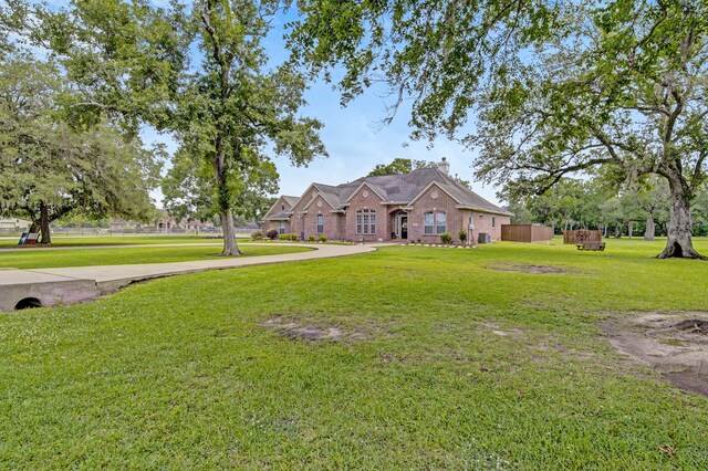 view of front of house with a chimney, a front lawn, and brick siding
