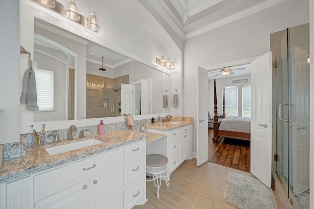 ensuite bathroom with ceiling fan, vanity, a shower stall, ensuite bathroom, and ornamental molding