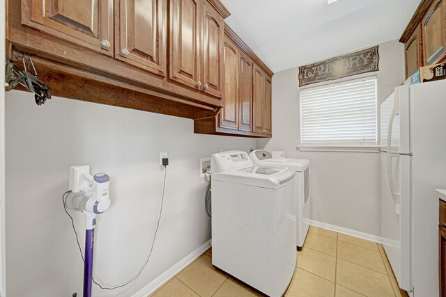 laundry room with baseboards, cabinet space, washing machine and dryer, and light tile patterned flooring