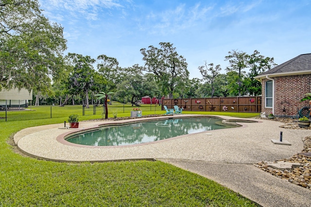 view of swimming pool featuring a lawn, a patio, a pool with connected hot tub, and fence