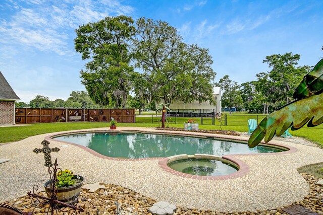 view of swimming pool with a lawn, fence, and a pool with connected hot tub