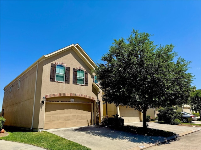 view of front of house with a garage, stucco siding, and driveway