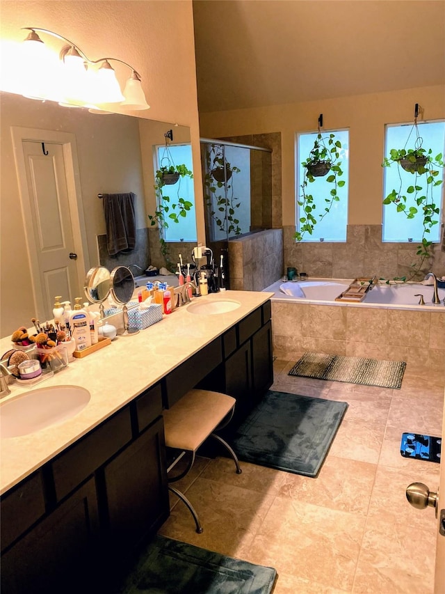 bathroom featuring double vanity, a sink, a garden tub, and a stall shower