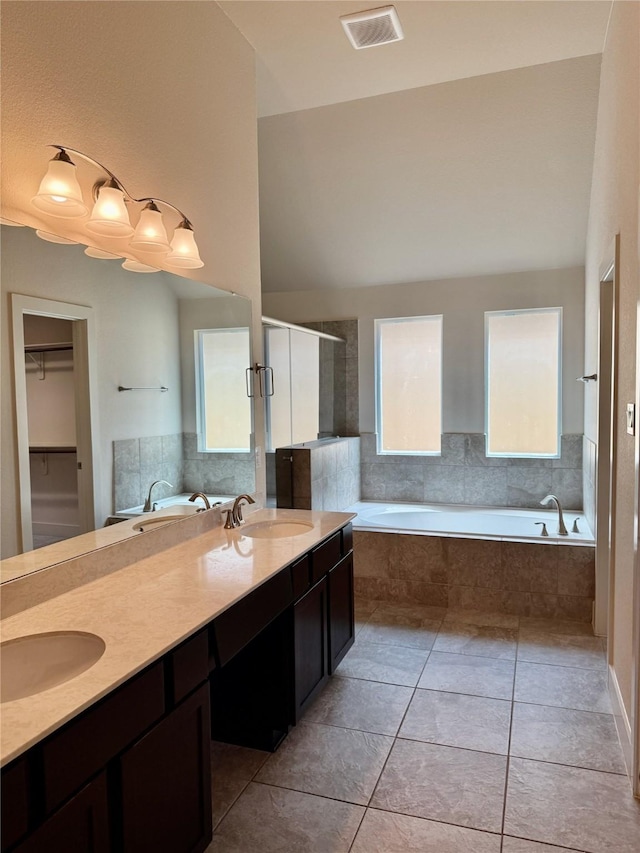 full bathroom with a sink, a wealth of natural light, a bath, and visible vents
