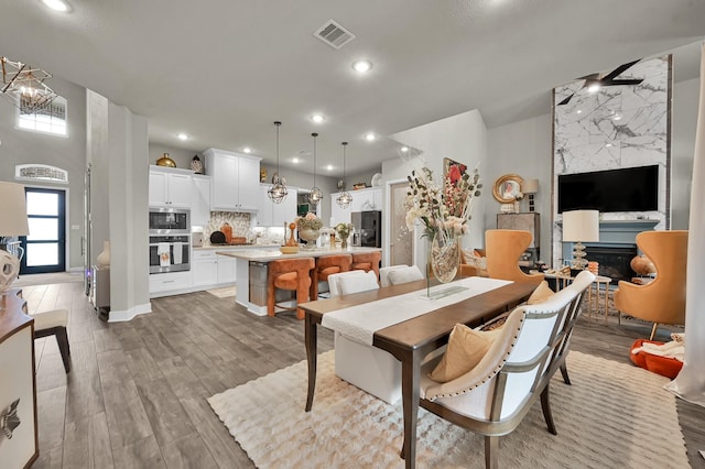 dining space with recessed lighting, light wood finished floors, and visible vents