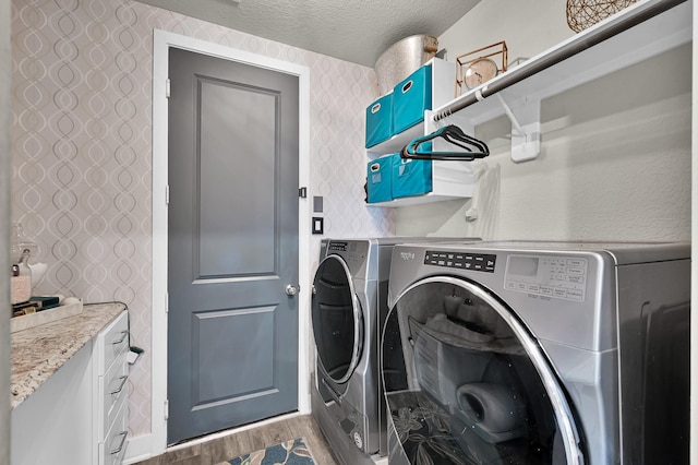 laundry room featuring laundry area, a textured ceiling, washing machine and dryer, wood finished floors, and wallpapered walls