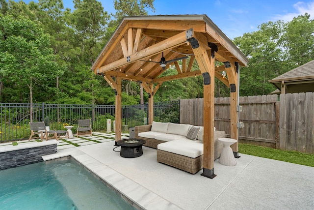 view of patio / terrace with a fenced in pool, an outdoor living space with a fire pit, a gazebo, and a fenced backyard