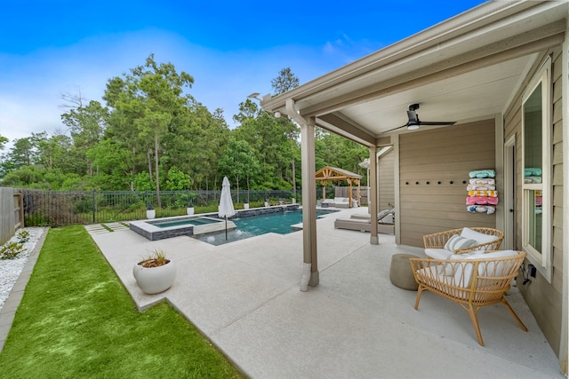 view of swimming pool with a fenced backyard, a ceiling fan, a pool with connected hot tub, and a patio area