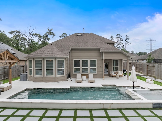 back of house with a fenced in pool, a fenced backyard, a patio area, and a shingled roof