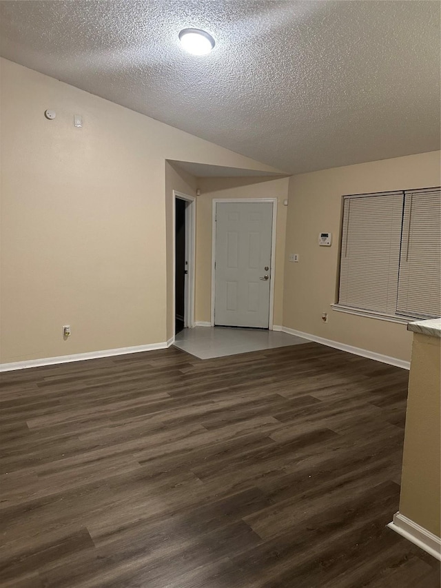 empty room featuring baseboards, dark wood finished floors, and a textured ceiling