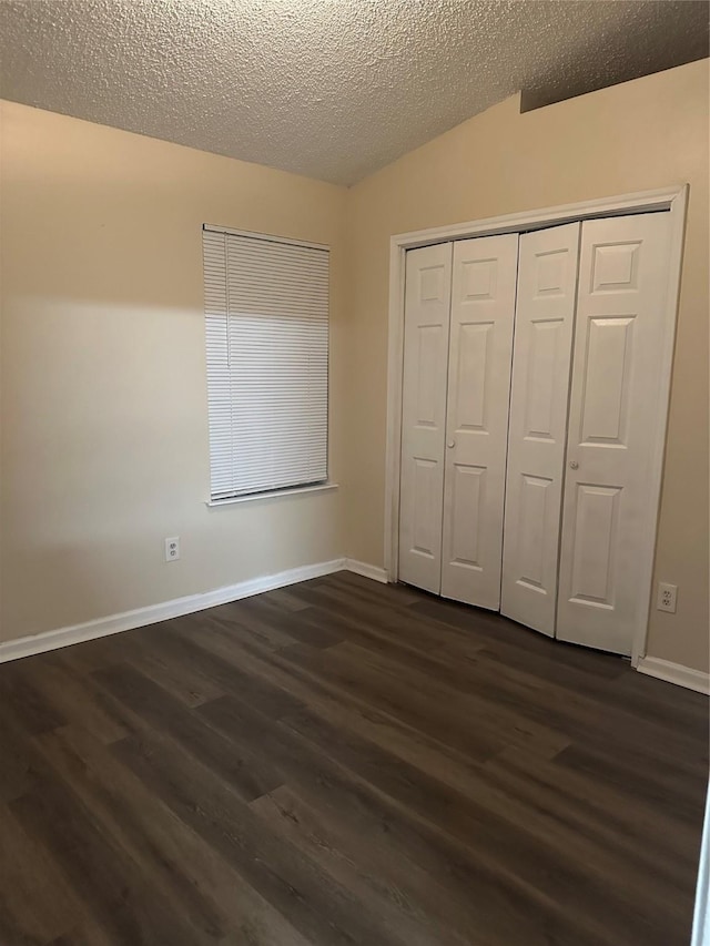unfurnished bedroom with baseboards, a closet, dark wood finished floors, and a textured ceiling