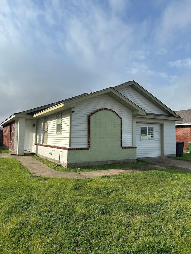 view of side of property with a yard and brick siding