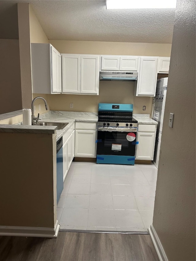 kitchen with stainless steel electric range oven, a sink, light countertops, white cabinetry, and under cabinet range hood