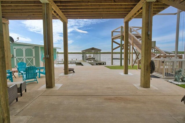 517 Private Road 675, Sargent, TX 77414 - view of patio with an outdoor structure, boat lift, a boat dock, a shed, and a water view