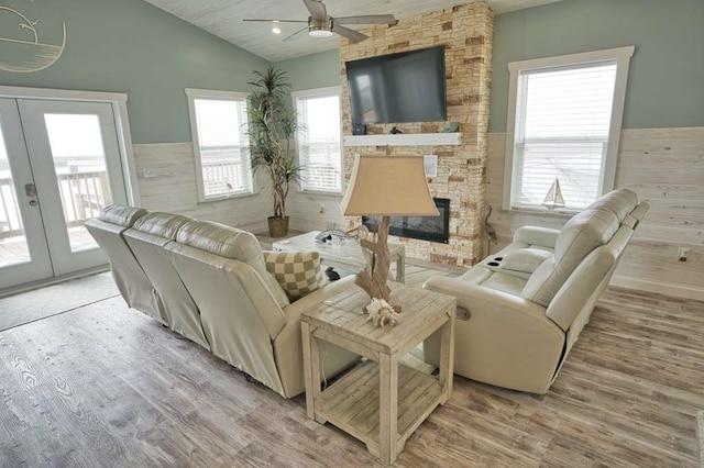 517 Private Road 675, Sargent, TX 77414 - living room featuring a stone fireplace, french doors, a ceiling fan, wood finished floors, and vaulted ceiling