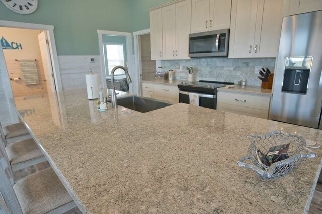 517 Private Road 675, Sargent, TX 77414 - kitchen with a sink, appliances with stainless steel finishes, a spacious island, and light stone counters