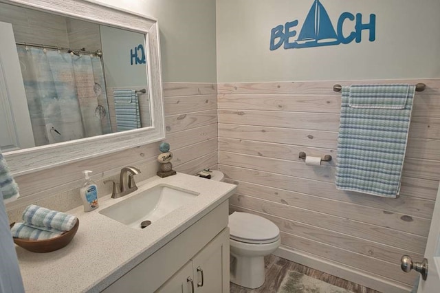 517 Private Road 675, Sargent, TX 77414 - bathroom with vanity, wainscoting, curtained shower, wood finished floors, and toilet