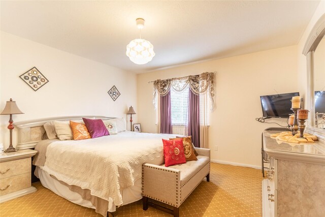 bedroom with baseboards and light carpet