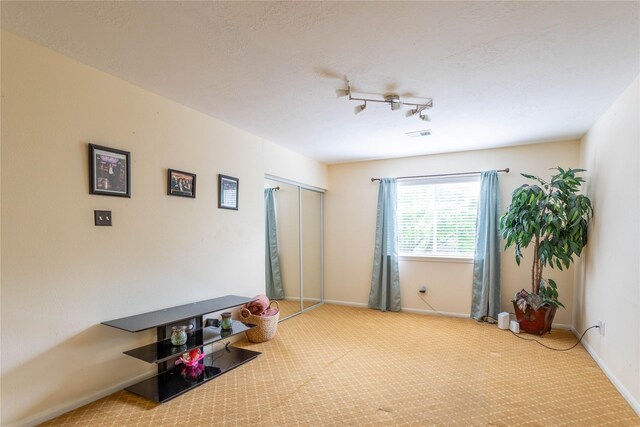 interior space featuring carpet floors, rail lighting, and baseboards