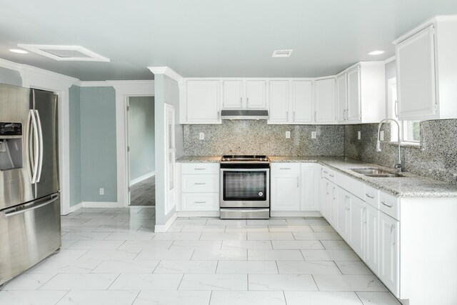 kitchen featuring light stone countertops, appliances with stainless steel finishes, a sink, under cabinet range hood, and visible vents