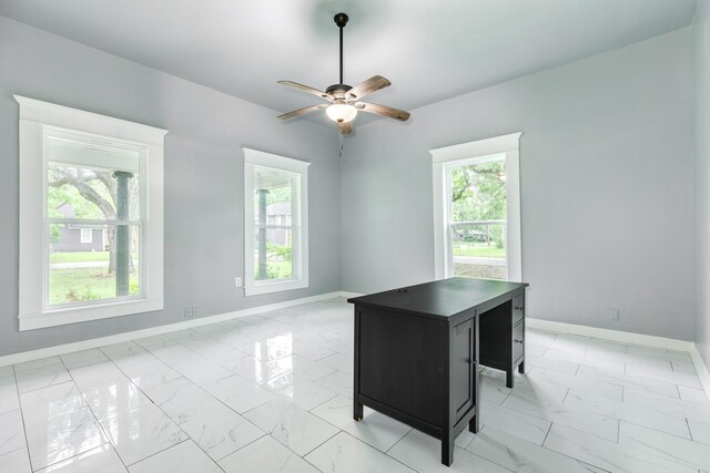 unfurnished office with baseboards, plenty of natural light, ceiling fan, and marble finish floor