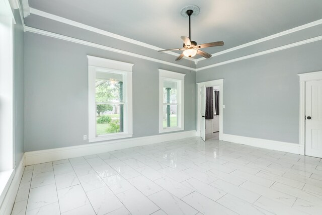 empty room with crown molding, baseboards, a ceiling fan, and marble finish floor