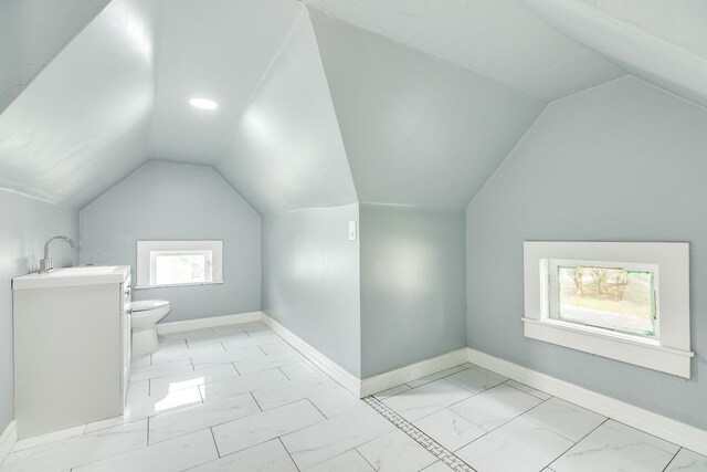 bonus room with a sink, baseboards, vaulted ceiling, and marble finish floor