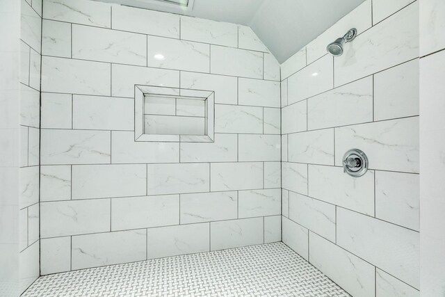 full bath with vaulted ceiling and tiled shower