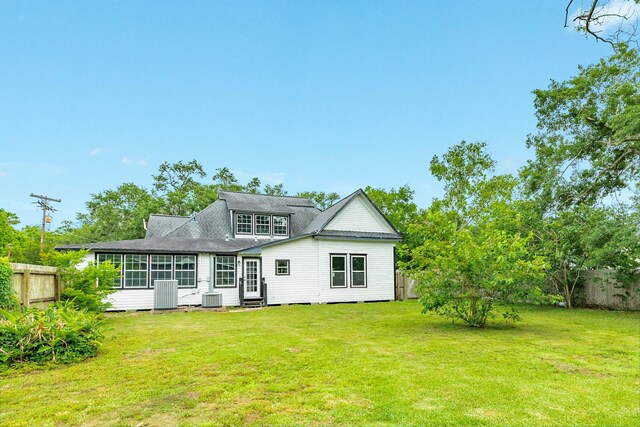 rear view of house featuring central air condition unit, fence, and entry steps